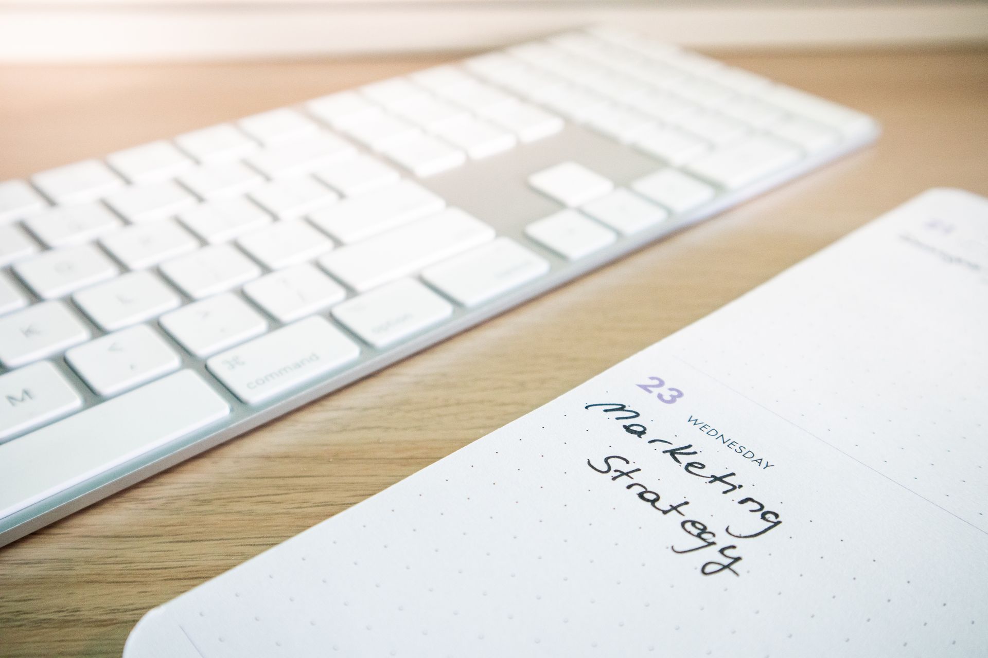 Planner com a anotação 'Marketing Strategy' ao lado de um teclado, representando planejamento de marketing digital